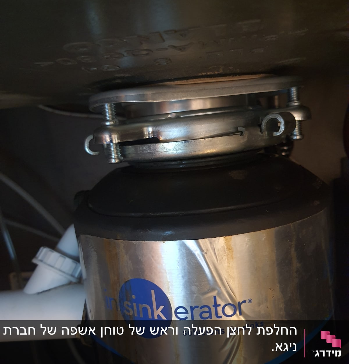 מכשיר טוחן אשפה מתחת לכיור עם צינור לבן